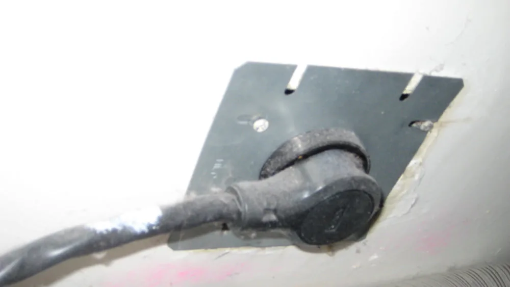 A 240 volt dryer cord plugged into a wall outlet