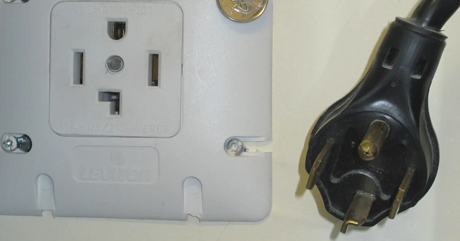 A NEMA 14-30 dryer receptacle beside its four prong plug