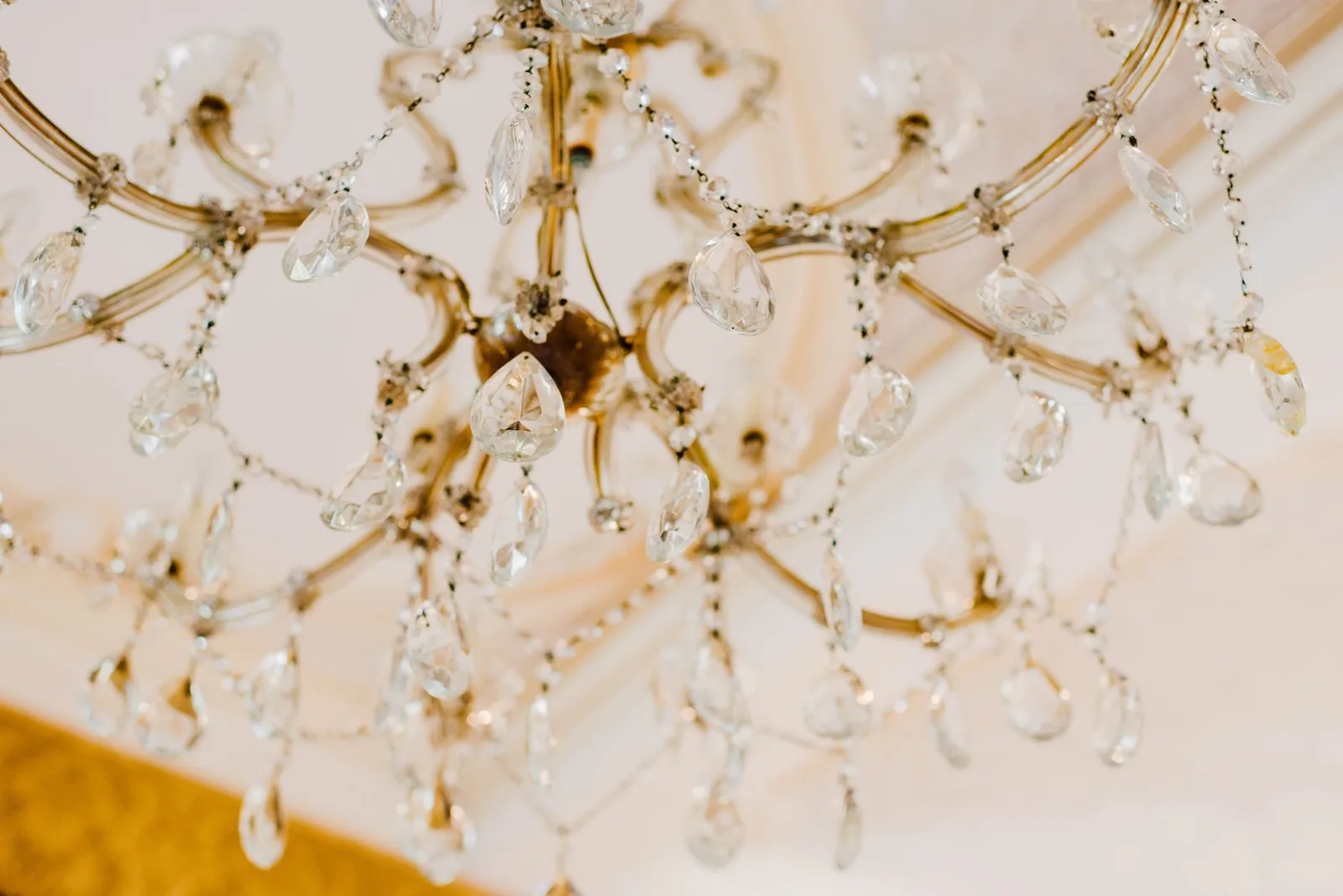 Gold and crystal chandelier hanging from a ceiling