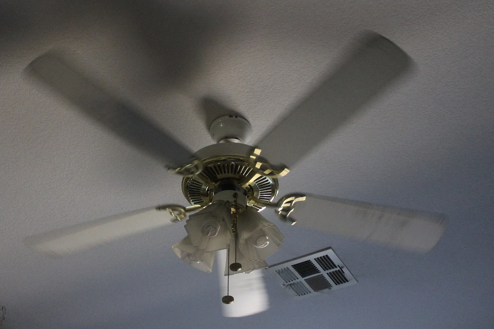 Spinning ceiling fan with a light kit