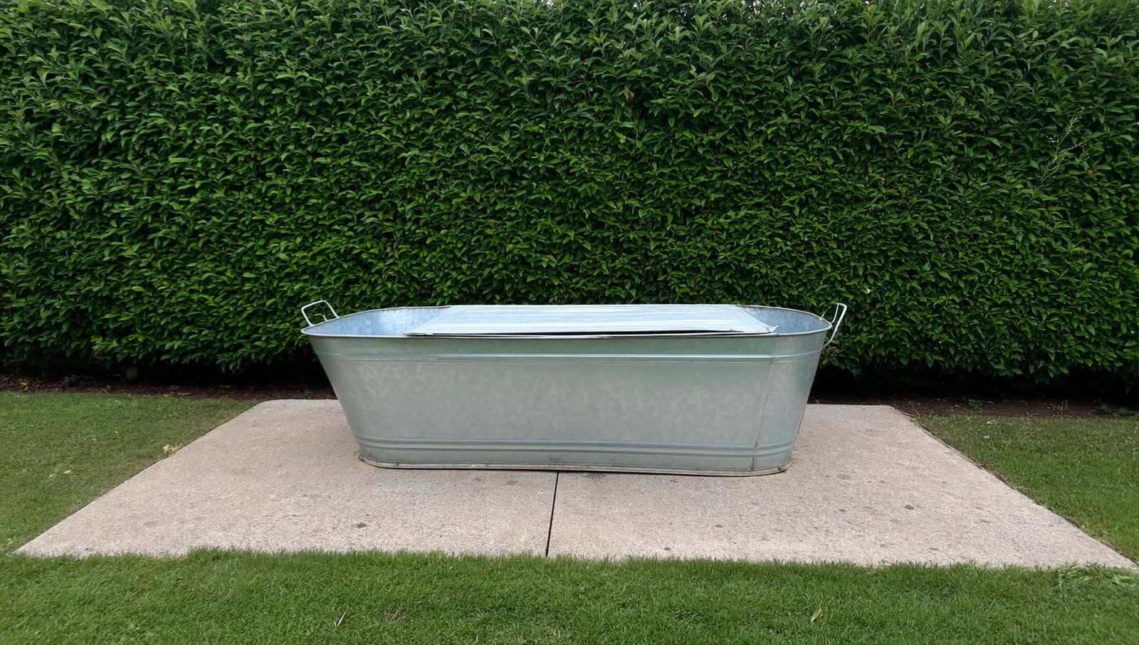 Galvanized metal tub on a concrete patio slab