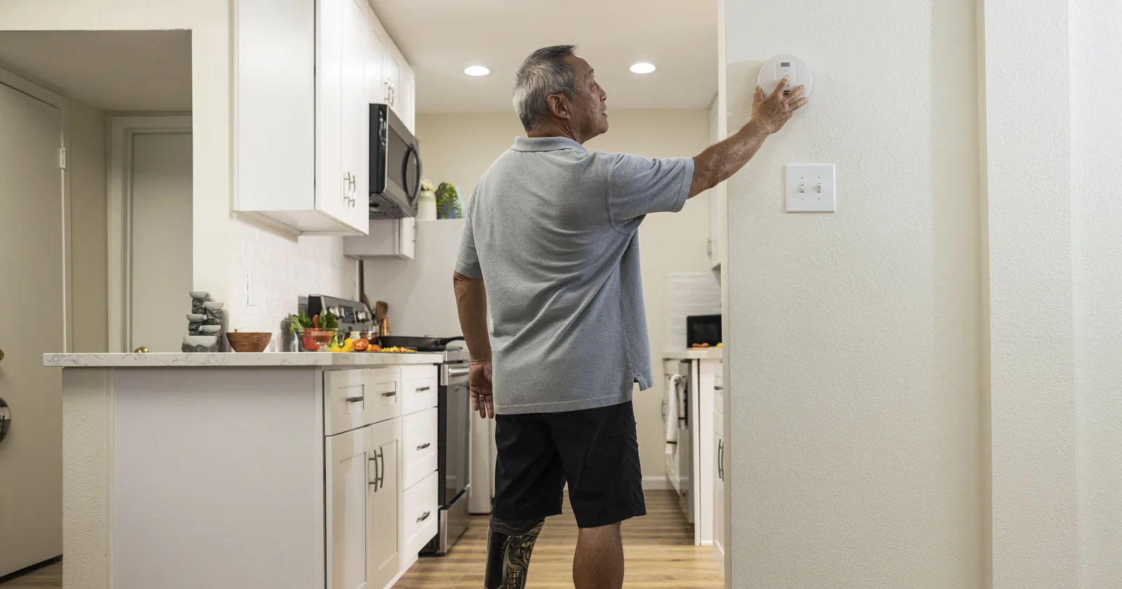 Man pressing the test button on a smoke alarm