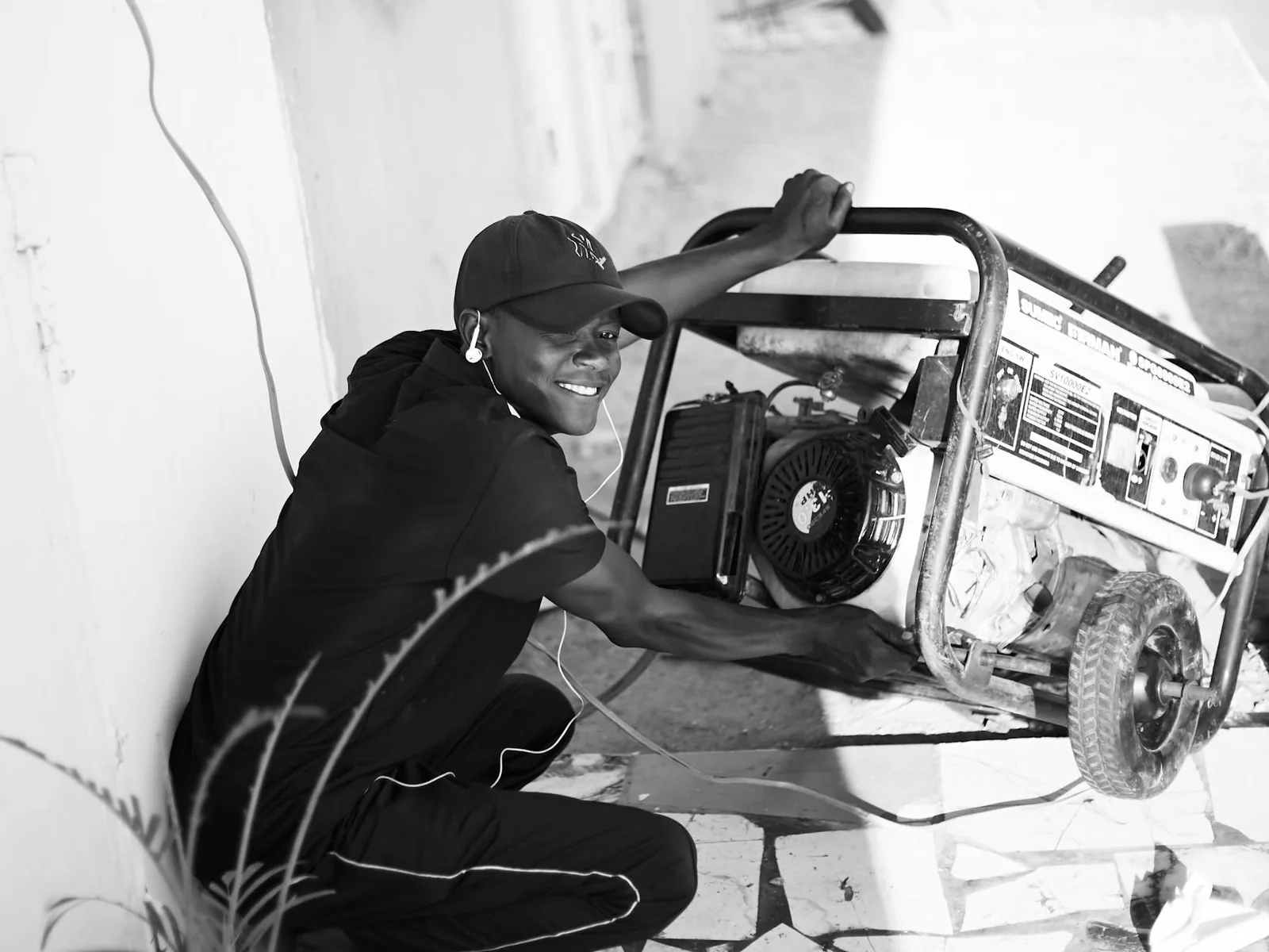 A man operating a portable generator outdoors, well away from the house.