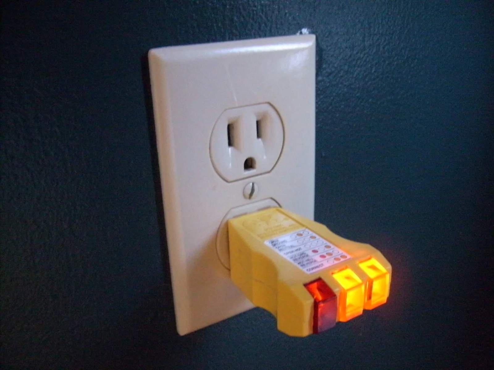Plug-in outlet tester in a wall receptacle